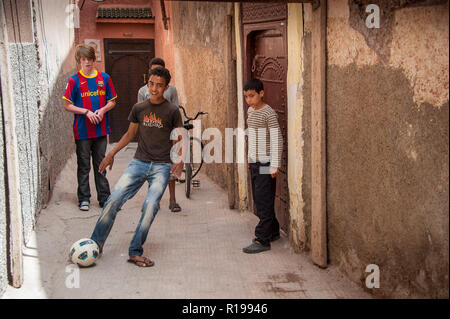 18-04-11. Marrakesch, Marokko. Englischen Jungen Fußball spielen mit marokkanischen Jungen, die in einer Gasse in der Medina. Foto © Simon Grosset/Q-Fotografie Stockfoto