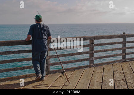 Ein Mann Angeln vom Steg über dem Pazifischen Ozean in Oceanside, Kalifornien, USA Stockfoto