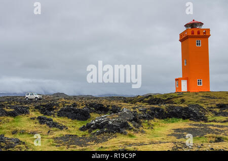 Das Auto vor orange Leuchtturm auf den Felsen in Island,, Snaefellsnes Peninsulain Stockfoto