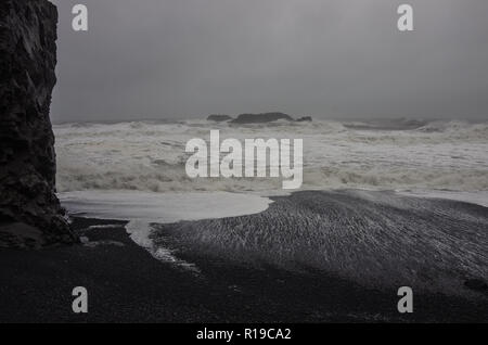 Schwarzer Sand Strand Reynisfjara am Ufer des Atlantischen Ozeans mit riesigen Wellen im Süden von Island, Europa Stockfoto