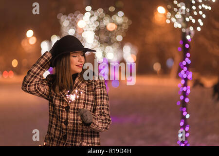 Junge Mädchen, dass Wunderkerzen für Weihnachten im Winter allein im Park Stockfoto