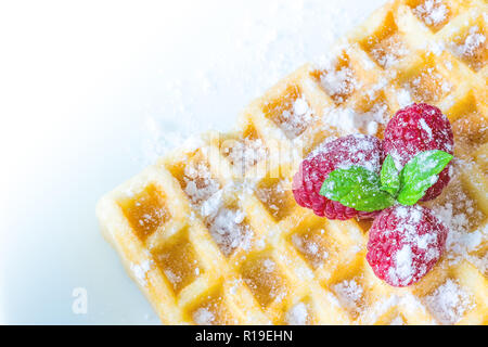 Sweet Toast, Waffeln Frühstück mit Himbeeren und Zucker Pulver und mit Zweig Minze auf Makro Nahaufnahme auf weißem Hintergrund Stockfoto