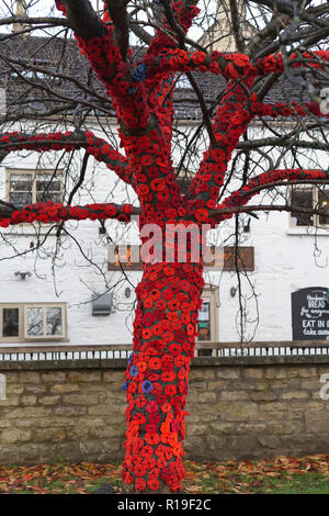 Clock Tower Kriegerdenkmal in der Mitte des Cotswold Stadt Nailsworth ist gestrickt Roter Mohn Erinnerung Sonntag zu gedenken geschmückt Stockfoto