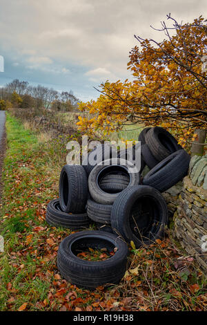 Ein Haufen von gebrauchten Autoreifen entleert auf Seite eines ziemlich country lane in Einsiedler Hill, Wortley, Sheffield, Großbritannien Stockfoto