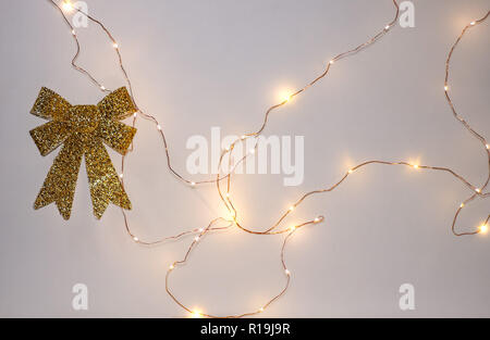 Leuchtende elektrische Girlanden auf einem weißen Hintergrund. Lichter von Garland an der Wand. Weihnachten Dekoration in Form eines Bogens. Stockfoto