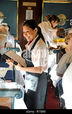 Eine Kellnerin, die Frühstücksbestellungen von Passagieren an Bord des erstklassigen Restaurants des Ghan-Zuges in Australien entgegennimmt Stockfoto