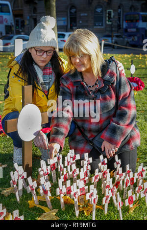 Glasgow, UK. 10 Nov, 2018. Als die Nation Erinnerung Sonntag Ansätze, Mitglieder der Öffentlichkeit weiterhin die British Legion Garten der Erinnerung zu besuchen, um ihren Respekt zu bekunden und Mohn und Kreuze mit Ihren persönlichen Nachrichten an diejenigen, die in allen Kriegen getötet wurden, zu verlassen. Den Garten können für alle Regimenter, Religionen und Nationalitäten zu erkennen und zu erinnern. Hier JANETTE WATT und ihrer Schwiegertochter STEPHENIE CAINE sowohl aus Glasgow, lassen ein poppiger zu merken TOMMY BRAUN, die in der Tätigkeit in Afghanistan im Jahr 2009 Credit getötet wurde: Findlay/Alamy leben Nachrichten Stockfoto