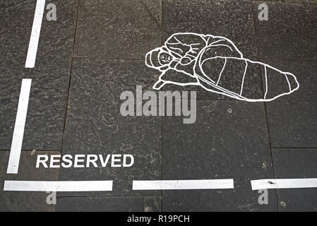 Edinburgh, der Royal Mile, 10. November 2018. Ein anonymer street artist macht eine Aussage über die Obdachlosigkeit in Form einer â € "reservedâ €™-Bereich mit Markierungslinien in der Form eines Obdachlosen auf der Royal Mile, Edinburgh, Schottland, Großbritannien. Stockfoto