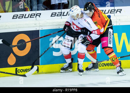 Krefeld, Deutschland. 11 Nov, 2018. Eishockey: Deutschland Cup, Deutschland - Schweiz, 2. Spieltag. Schweizer Lukas Frick (l) und Deutschlands Leonhard Niederberger Kampf um den Puck. Credit: Marcel Kusch/dpa/Alamy leben Nachrichten Stockfoto