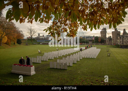 Cardiff, Großbritannien. 10. November 2018. Besucher und Rugby Unterstützer auf der Replik Commonwealth Kriegsgräber Kommission Friedhof an den Hof von Cardiff Castle installiert zu markieren, um den 100. Jahrestag des Waffenstillstandes vor Wales verse Australien Rugby Spiel im Fürstentum, das Stadion, das im Hintergrund zu sehen. Kredit Haydn Denman/Alamy leben Nachrichten Stockfoto