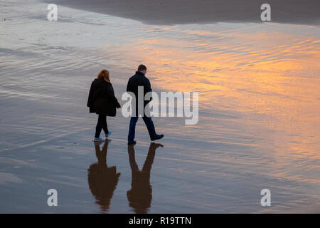 Blackpool, Lancashire, UK. 10 Nov, 2018. UK Wetter. Ein paar am späten Nachmittag einen Spaziergang auf dem goldenen Sand der Fylde Coast genießen. Kredit; Quelle: MediaWorldImages/Alamy leben Nachrichten Stockfoto