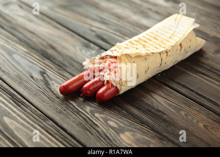 Hausgemachte Wurst in pita Brot auf hölzernen Hintergrund. Foto mit Stockfoto