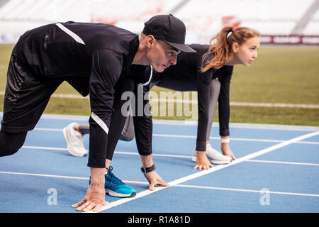 Nahaufnahme Seitenansicht erschossen. Junge Läufer sind in der Start konzentriert Stockfoto