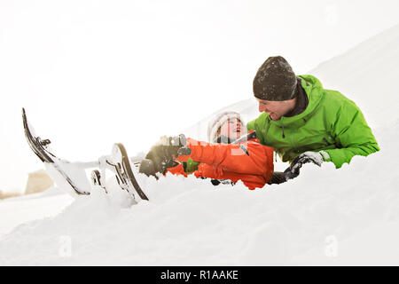 Ein netter Vater und Sohn auf dem Schlitten sitzen Stockfoto