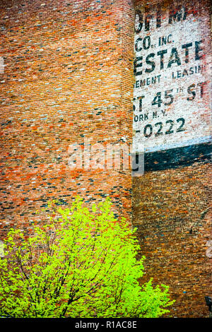 Fading ad Fragment auf ein Red brick wall in New York City, New Yerk, Vereinigte Staaten von Amerika Stockfoto