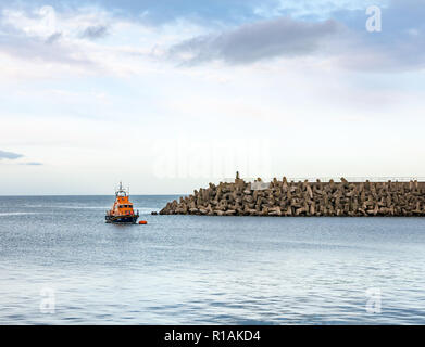 RNLI lifeboat Sir John Neville vertäut am Kernkraftwerk Torneß und dolos konkrete Meer Barriere, East Lothian, Schottland, Großbritannien Stockfoto