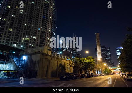 Chicago night street Szene mit einem City Tower, ein Schornstein, der Skyline, Wolkenkratzer und der Mond im Hintergrund. Stockfoto