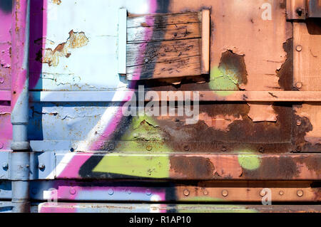 Bunte Graffiti auf einem Zug Wagen mit violetten und gelben Farben Stockfoto