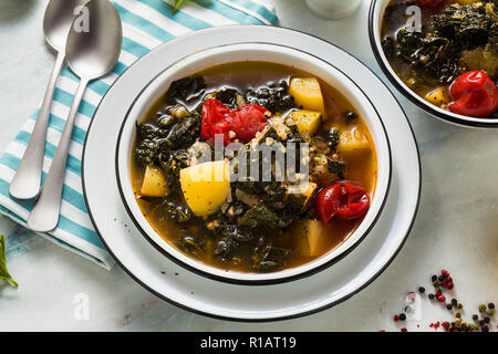 Veganer winter Grünkohl Kartoffelsuppe mit Buchweizen, Cherry Tomaten und Kartoffeln. Lecker voll Gemüse Lebensmittel für die ganze Familie. Stockfoto