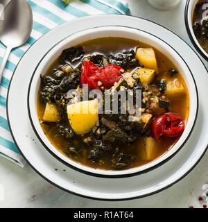 Veganer winter Grünkohl Kartoffelsuppe mit Buchweizen, Cherry Tomaten und Kartoffeln. Lecker voll Gemüse Lebensmittel für die ganze Familie. Stockfoto