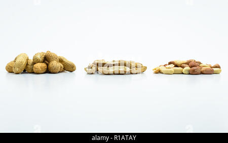 Erdnüsse in der Schale und ohne Schalen auf weißem Hintergrund mit Freistellungspfad isoliert. Stockfoto