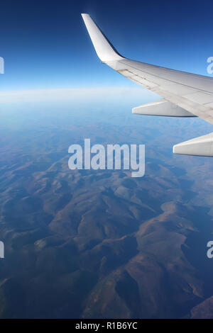 Berglandschaft unter dem Flügel eines Flugzeugs Stockfoto