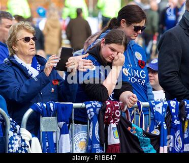 Leicester. 11 Nov, 2018. Ein Unterstützer wischt sich Tränen, als sie einen Blick die Tribute für Leicester City Vorsitzender Vichai Srivaddhanaprabha, der bei einem Hubschrauberabsturz außerhalb der King Power Stadion enthalten Links, vor der Englischen Premier League Match zwischen Leicester City FC und Burnley FC für die King Power Stadion in Leicester, Großbritannien am 10. November 2018. Das Spiel endete 0:0. Quelle: Xinhua/Alamy leben Nachrichten Stockfoto