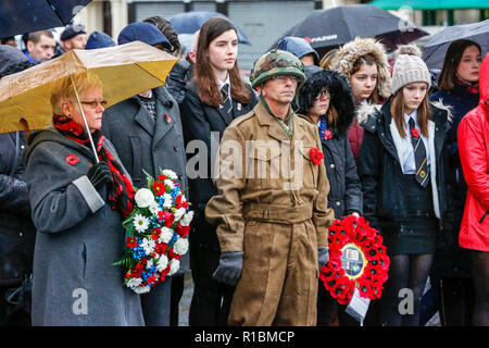 Saltcoats, Ayrshire, UK. 11 Nov, 2018. Starker Regen und starken Wind nicht davon abhalten, über 1000 Menschen aus dem Wenden am Ehrenmal und Kriegerdenkmal in Saltcoats, Ayrshire, GROSSBRITANNIEN, um ihren Respekt zu zeigen, legen Tribute der Kränze und an den Tag des Gedenkens nehmen zum Gedenken an 100 Jahre seit der Beendigung der Konflikte in der Welt Krieg 1 Credit: Findlay/Alamy leben Nachrichten Stockfoto