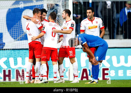 Magdeburg, Deutschland. 11 Nov, 2018. Fussball: 2. Fussballbundesliga, 13. Spieltag, 1.FC Magdeburg - SSV Jahn Regensburg in der MDCC-Arena. Der Regensburger Spieler jubeln nach dem Sieg. Magdeburg ist Marcel kostspielig ist enttäuscht. Quelle: Joachim Sielski/dpa - WICHTIGER HINWEIS: In Übereinstimmung mit den Anforderungen der DFL Deutsche Fußball Liga oder der DFB Deutscher Fußball-Bund ist es untersagt, zu verwenden oder verwendet Fotos im Stadion und/oder das Spiel in Form von Bildern und/oder Videos - wie Foto Sequenzen getroffen haben./dpa/Alamy leben Nachrichten Stockfoto