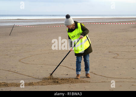 Redcar North Yorkshire, UK. 11 Nov, 2018. Das 100-jährige Jubiläum des Waffenstillstandes, der Erste Weltkrieg endete. Die Seiten des Sea-Projekt, geleitet von Danny Boyle, Porträts von Krieg verletzten in den Sand an den Stränden rund um den britischen geschnitzt, bei Flut gewaschen zu werden. In Redcar wurde das Thema Theophilus Jones, am 16/12/1914 während der Bombardierung von Hartlepool enthalten. Die Einheimischen waren auch ermutigt, Sand Bilder von Beziehungen, die im Krieg gestorben. Viele davon wurden mit Hilfe von den Organisatoren, die bereitgestellten Vorlagen. Credit: Peter Jordan NE/Alamy leben Nachrichten Stockfoto