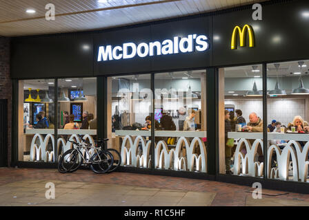 Die renovierten McDonald Restaurant zeigen Menschen in Essen fast food in Worthing, West Sussex, England, UK. Stockfoto