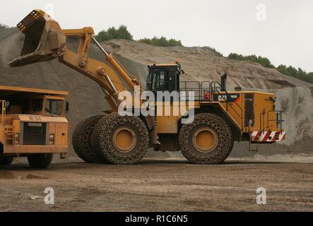 Eine Raupe mit Rädern laden Schaufel Arbeiten in einem Steinbruch in Leicestershire Stockfoto