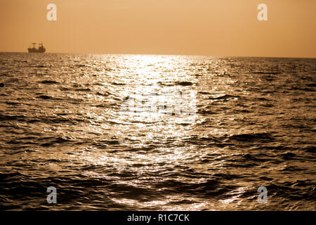 Landschaft Meer mit Wellen und Sonnenuntergang Himmel mit einem Schiff Stockfoto