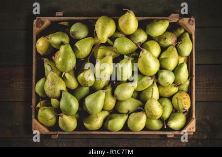 Organische Birnen in einem hölzernen Kasten von oben Stockfoto