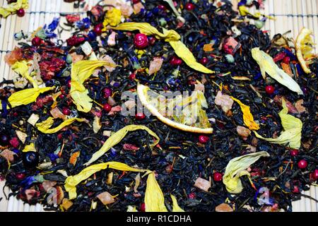 Die duftende und frische grüne Stunde liegt auf einem Bambus Oberfläche. Die Zusammensetzung der Kaffee enthält leckere Stücke von Erdbeere, Wacholderbeeren, Tangier Stockfoto