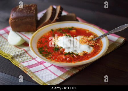 Traditionelle ukrainische Russischen Borschtsch auf der Schüssel. Platte von Rot Rote Beete Suppe Borschtsch auf Schwarz rustick Tabelle. Traditionelle ukrainische Essen Küche Stockfoto