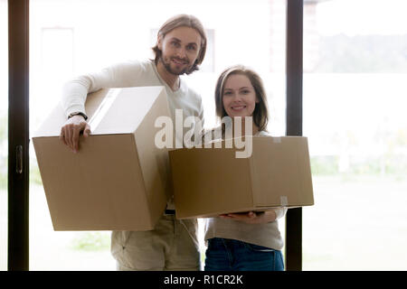 Paar stehend mit ungeöffneten Kartons an Kamera suchen Stockfoto