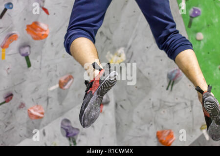 Die Beine, Kletterer in den Schuhen hängen an der Wand in einem Sprung Stockfoto