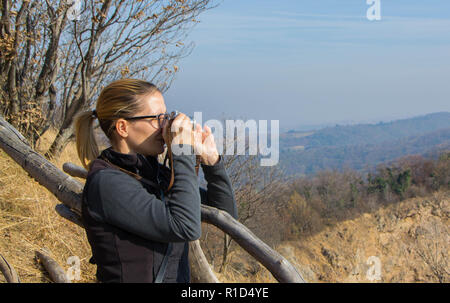 Eine Frau nimmt Bilder mit dem alten sowjetischen Entfernungsmesser film Kamera mit manueller Zurückspulen des Films für Fotografie zugeführt. Eine 35-mm-Kamera Stockfoto