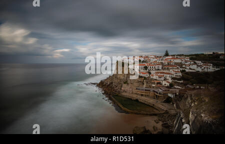 Schöne Häuser auf einer Felsenklippe an der Küstenort Azenhas do Mar in Portugal mit Atlantik Wellen schlagen der Küste. Stockfoto