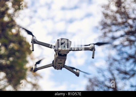 Drohne fliegen in die Luft, sichtbare Bäume und der blaue Himmel Stockfoto