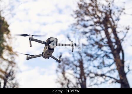 Drohne fliegen in die Luft, sichtbare Bäume und der blaue Himmel Stockfoto