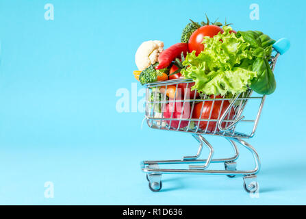 Warenkorb mit frischem Gemüse close-up auf blauem Hintergrund Stockfoto