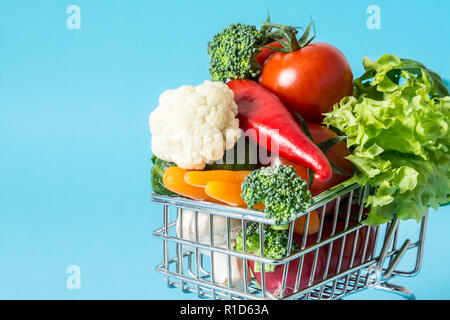 Warenkorb mit frischem Gemüse close-up auf blauem Hintergrund Stockfoto