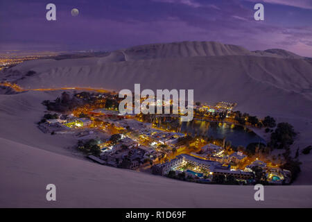 Die Nacht der Huacachina Oase von Dünen im Norden Perunear Ica umgeben beleuchtet durch den Mond. Stockfoto