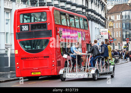 London England, Großbritannien, South Bank Southwark, Borough High Street, Tretbus Pub, Fahrradparty, Crawler, Bierbierbike, ein vom Menschen angetriebenes Fahrzeug, roter Doppeldeckerbus Stockfoto