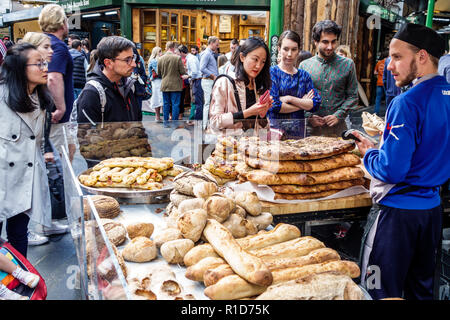 London England, Großbritannien, South Bank Southwark, Borough Market, Verkaufsstände, Bäckerei, handwerkliches Brot, Brote, asiatische Frau weibliche Frauen, Männer männlich, Kauf, sellin Stockfoto