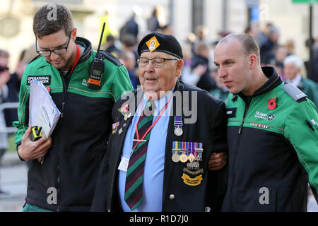 St John Ambulance Personal gesehen bei einem kriegsveteranen nach krank während der jährlichen Erinnerung an den 100. Jahrestag des Waffenstillstandes Prozession in London Tribut zu denen, die gelitten haben oder während des Krieges starb zu bezahlen. Hunderte von Menschen versammelt, um gemeinsam den 100. Jahrestag des Waffenstillstandes, die sah, 3.123 cm Mitglieder der bewaffneten Kräfte ihr Leben verloren, zu markieren. Der Waffenstillstand im Ersten Weltkrieg zwischen den Alliierten und Deutschland in Compiegne, Frankreich auf der elften Stunde des elften Tag des elften Monats unterzeichnet wurde - 11:00 Uhr Am 11. November 1918. Stockfoto