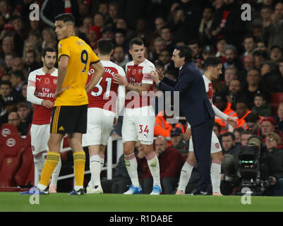 London, Großbritannien. 11. Nov 2018. Mesut Ozil (A) geht hinter Unai Emery (Arsenal manager) nach im Arsenal v Wolverhampton Wanderers (Wölfe) die Englische Premier League Spiel ersetzt wird im Emirates Stadium, London, am 11. November 2018. ** Dieses Bild ist für die redaktionelle Nutzung nur ** Quelle: Paul Marriott/Alamy leben Nachrichten Stockfoto