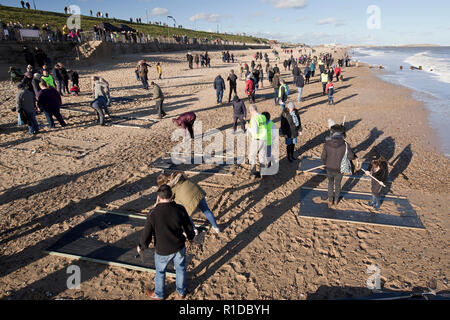 Gorleston-On - Meer, Norfolk. 11. November 2018. Menschenmengen auf Gorleston Strand versammeln sich Danny Boyle's Allgemein "Seiten der Erinnerung" zu beteiligen, markiert das Ende des Ersten Weltkriegs vor 100 Jahren, viele Ihrer eigenen künstlerischen Beiträge im Sand der Erinnerung an die Personen, die unsere Ufer links und kehrte nie zurück. Credit: Adrian Buck/Alamy leben Nachrichten Stockfoto